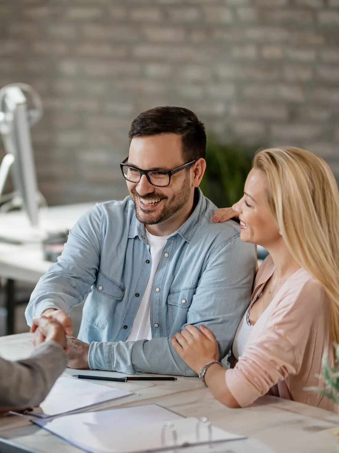 A couple shaking hands with their mortgage advisor