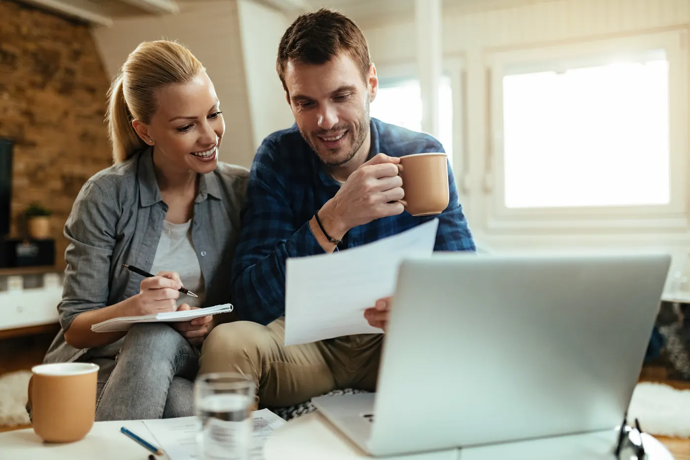 A couple at home going over their budget and pay stubs together